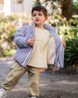 Child wearing a striped puffer jacket in an outdoor setting