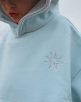 Light blue fleece jacket with a star design on a blurred natural background