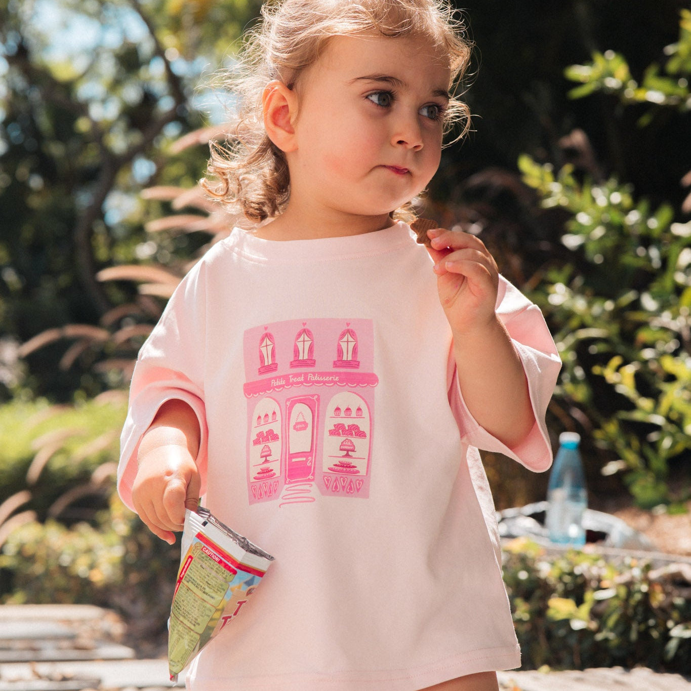 Young girl in a pink dress with a building design outdoors