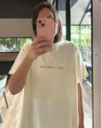 Woman taking a mirror selfie wearing a yellow t-shirt with Mum needs a margi print