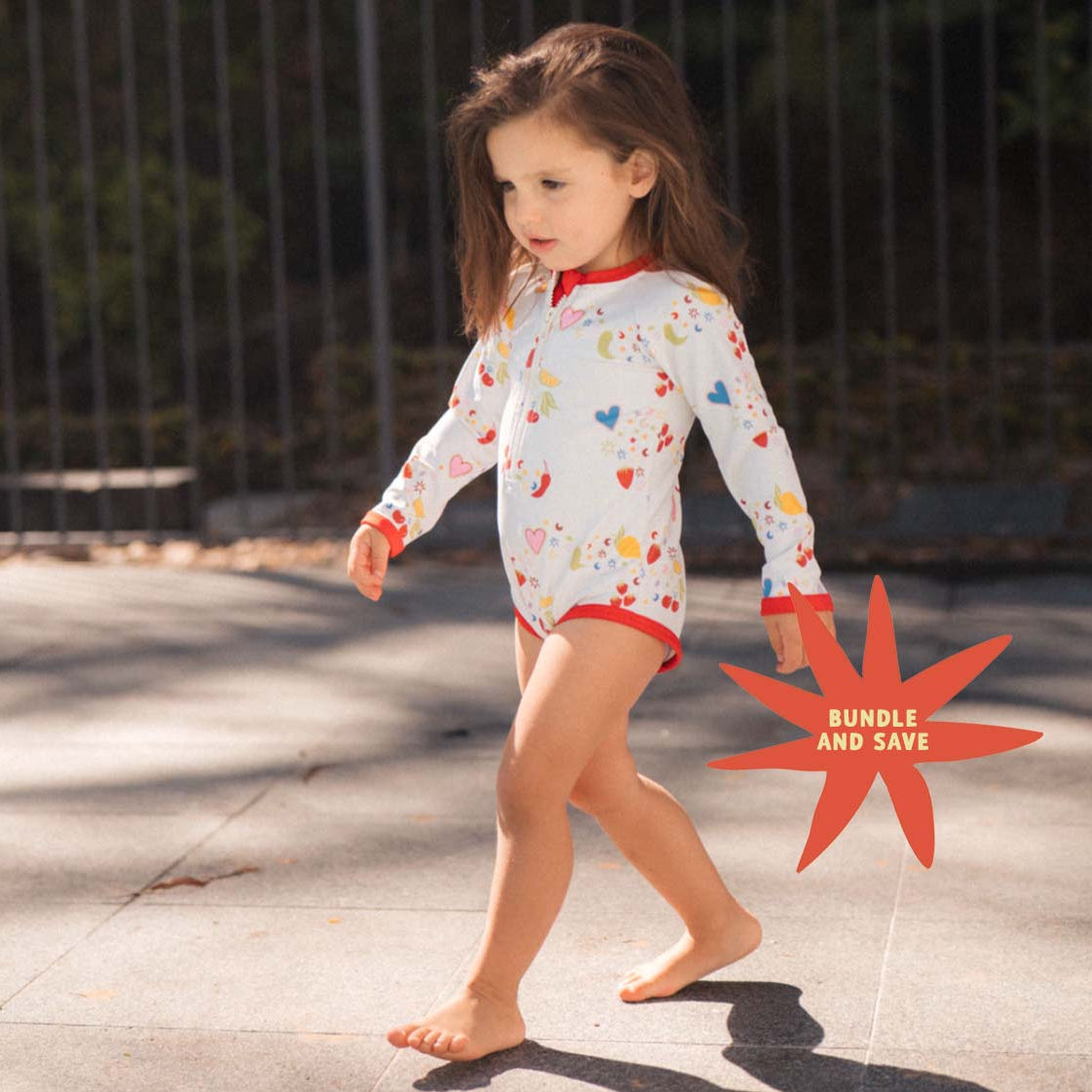 Child wearing a colorful swimsuit walking outdoors with a bundle & save graphic.